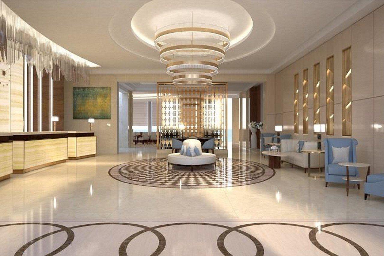 Grand Swiss-Belhotel Waterfront Seef Sanabis Exterior foto The photo shows a modern and elegant lobby area. It features a high ceiling adorned with stylish light fixtures. In the center, there is a round seating arrangement with a decorative piece. The floor has a sophisticated pattern, likely made of marble